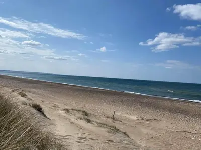a sandy beach with the ocean in the background at 6 person holiday home in Thisted in Thisted