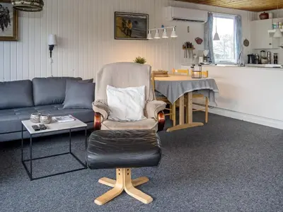 a living room with a couch and a chair and a table at 6 person holiday home in Thisted in Thisted
