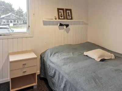 a bedroom with a bed and a nightstand and a window at 6 person holiday home in Thisted in Thisted