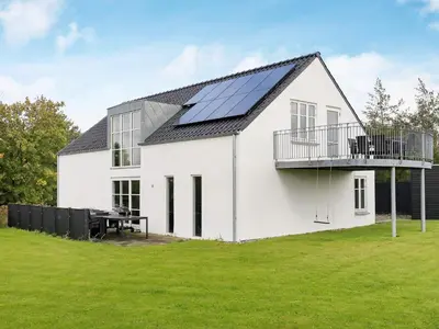 a white house with solar panels on the roof at 10 person holiday home in Ranum in Ranum