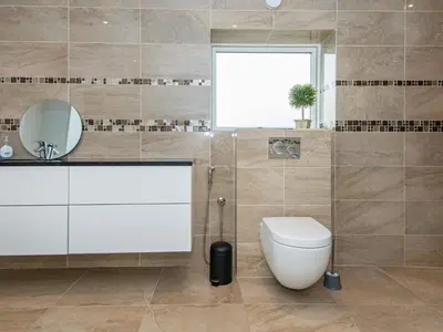 a bathroom with a toilet and a mirror at Tranquil Riverside Retreat in Holstebro