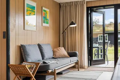 a living room with a couch and a balcony at BL1116-Blokhus-Bloksbjerg-24 in Blokhus