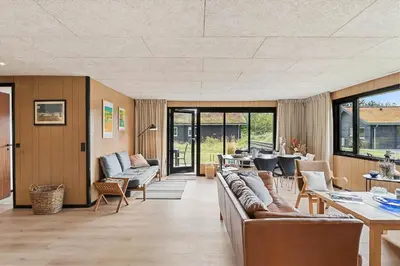 a living room with couches and a table and chairs at BL1116-Blokhus-Bloksbjerg-24 in Blokhus