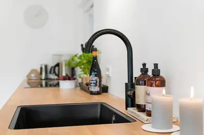 a kitchen sink with bottles of wine and candles at BL1116-Blokhus-Bloksbjerg-24 in Blokhus