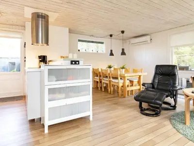 a kitchen and dining room with a table and a chair at 6 person holiday home in Blokhus