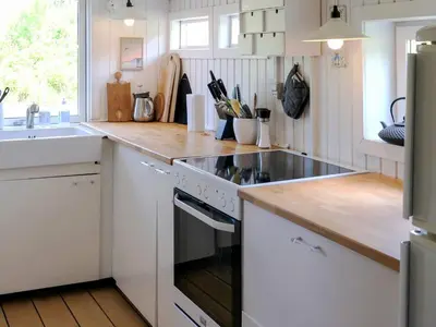 a kitchen with a stove top oven next to a sink at Welcoming 6 person holiday home in Blokhus in Blokhus