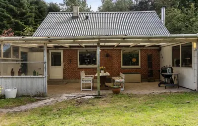 a brick house with a metal roof on a patio at Pet Friendly Home In Farsø With House A Panoramic View in Farsø