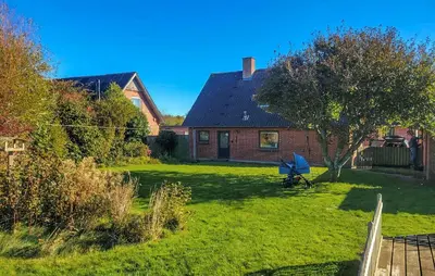 a house with a yard with a tree and a bench at Lovely Home In Karby With Wifi in Karby