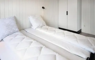 a large white bed in a room with a closet at 3 Bedroom Nice Home In Løgstrup in Løgstrup