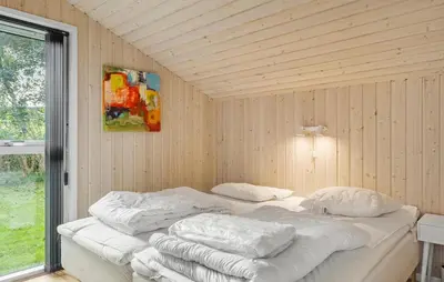 a bedroom with two beds in a wooden wall at Nice Home In Fjerritslev With Sauna in Fjerritslev