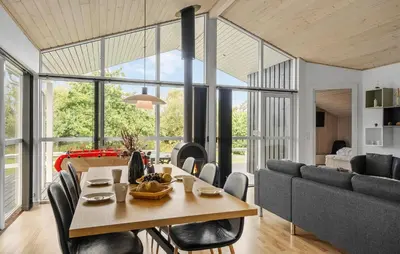 a dining room and living room with a table and chairs at Nice Home In Fjerritslev With Sauna in Fjerritslev