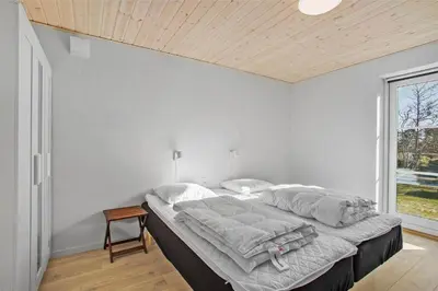 a bedroom with a large bed with a wooden ceiling at JB130-Fjerritslev-Thorup-Strandvej-274 in Fjerritslev