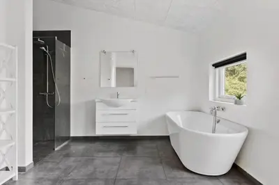 a white bathroom with a tub and a sink at JB241-Fjerritslev-Lyngstien-25 in Fjerritslev