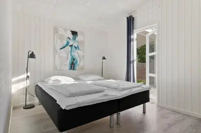 a bedroom with a bed with a painting on the wall at JB241-Fjerritslev-Lyngstien-25 in Fjerritslev
