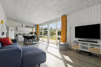a living room with a blue couch and a flat screen tv at JB241-Fjerritslev-Lyngstien-25 in Fjerritslev