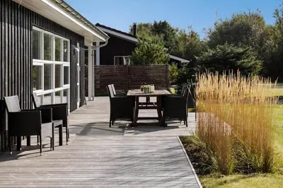 a wooden deck with a table and chairs on it at JB241-Fjerritslev-Lyngstien-25 in Fjerritslev