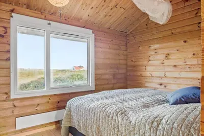 a bedroom with wooden walls and a bed and a window at JB356-Frostrup-Horsbakkevej-6 in Frøstrup