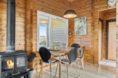 a dining room with a table and a wood stove at JB356-Frostrup-Horsbakkevej-6 in Frøstrup