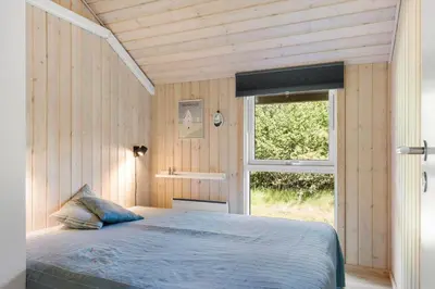 a bedroom with a bed in front of a window at JB232-Brovst-Kronvildtvej-20 in Brovst