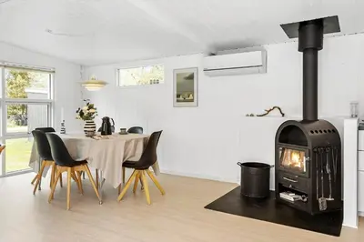 a living room with a table and a fireplace at JB323-Fjerritslev-Markstien-21 in Fjerritslev