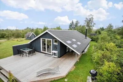 a small house with a deck with a table at JB578-Fjerritslev-Hasselvej-57 in Fjerritslev