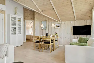 a living room with a dining room table and a tv at JB765-Brovst-Sletten-20 in Brovst