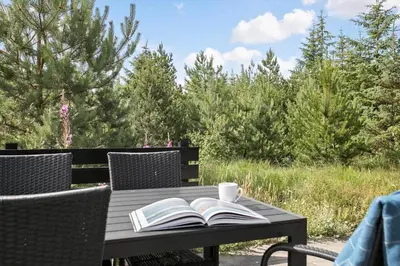 a wooden table with two books and a cup on it at JB193-Fjerritslev-Blabaerstien-78 in Fjerritslev