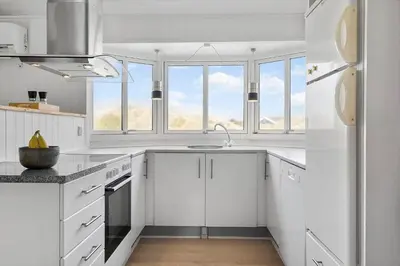 a white kitchen with a sink and some windows at JB183-Frostrup-Svenstibakkevej-70 in Frøstrup