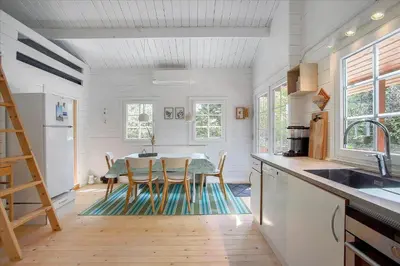 a kitchen with a table and chairs and a kitchen with white walls at JB160-Fjerritslev-Skovstien-7 in Fjerritslev