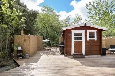 a small cabin with a white door on a wooden deck at JB160-Fjerritslev-Skovstien-7 in Fjerritslev