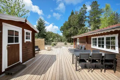 a wooden deck with a table and chairs on a cabin at JB160-Fjerritslev-Skovstien-7 in Fjerritslev