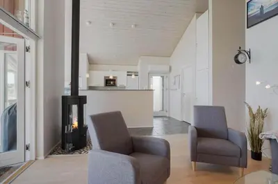 a living room with two chairs and a fireplace at JB326-Brovst-Kronvildtvej-134 in Brovst