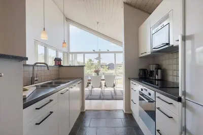 a kitchen with white cabinets and a large window at JB326-Brovst-Kronvildtvej-134 in Brovst
