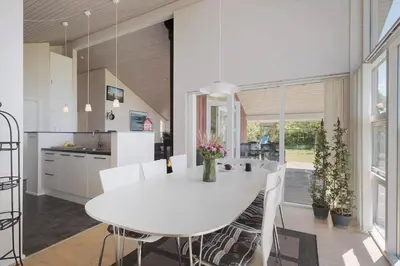 a kitchen and dining room with a white table and chairs at JB326-Brovst-Kronvildtvej-134 in Brovst