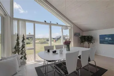 a dining room with a white table and chairs at JB326-Brovst-Kronvildtvej-134 in Brovst