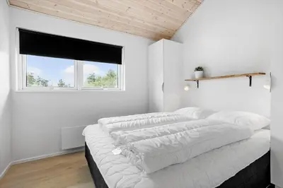 a white bedroom with four pillows on a bed at JB208-Brovst-Kronvildtvej-8 in Brovst