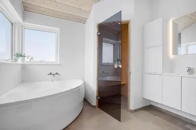 a white bathroom with a tub and a sink at JB208-Brovst-Kronvildtvej-8 in Brovst