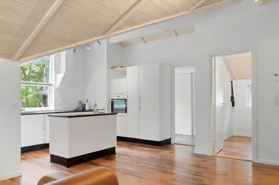 an open kitchen with white cabinets and a wooden floor at JB901-Aabybro-Graanden-40 in Åbybro