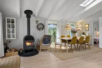 a living room with a fireplace and a dining table at JB922-Fjerritslev-Birkevej-25 in Fjerritslev