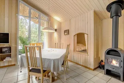 a dining room with a table and a wood stove at JB699-Fjerritslev-Revlingestien-43 in Fjerritslev
