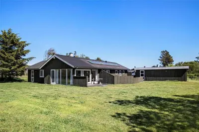 a black house in a field with a grass yard at JB785-Fjerritslev-Tolderstien-24 in Fjerritslev