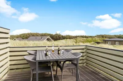 a table and chairs on a deck with a view of the beach at JB306-Brovst-Redningsvejen-18 in Brovst