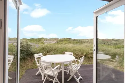 a patio with a white table and chairs on a deck at JB306-Brovst-Redningsvejen-18 in Brovst