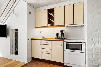 a small kitchen with white cabinets and a stove at JB889-Brovst-Strandvejen-150-Lejl-130 in Brovst