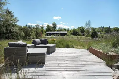 a patio with two couches and chairs on a wooden walkway at JB164-Fjerritslev-Poppelvej-16 in Fjerritslev
