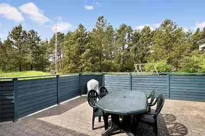a table and chairs on a patio with a fence at JB136-Brovst-Harestien-1 in Brovst