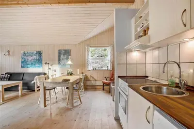 a kitchen with a table and a dining room at JB136-Brovst-Harestien-1 in Brovst