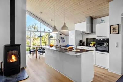 a kitchen with a fireplace in the middle of it at JB299-Brovst-Kronvildtvej-224 in Brovst