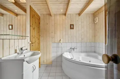 a bathroom with a tub and a sink at JB538-Fjerritslev-Tyttebaerstien-33 in Fjerritslev