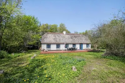 a white house with a thatched roof in a field at JB199-Fjerritslev-Svinklovvej-403 in Fjerritslev